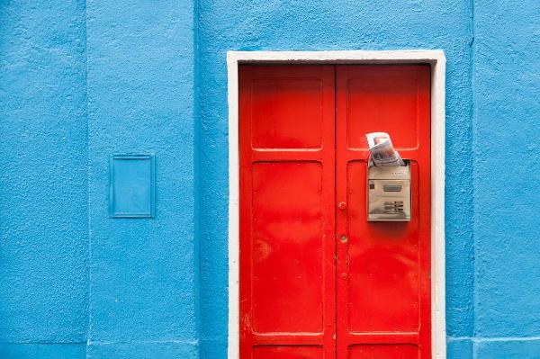 Milano - Particolare di un edificio - Facciata colorata - Porta d'ingresso rossa - Cassella postale in metallo con corrispondenza
