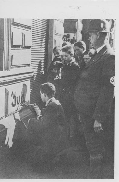 Nazismo - Austria, Vienna - Umiliazione di ebrei - Un bambino ebreo obbligato a scrivere "Jude" (ebreo) sul muro del negozio del padre - Folla (bambini e uomo con svastica / croce uncinata al braccio) - Antisemitismo