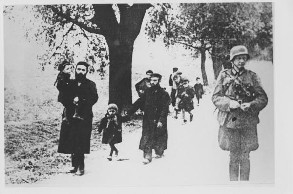 Nazismo - Polonia, vicinanze di Klobuck - Rastrellamento di ebrei: uomini e bambini in cammino - Deportazione - Ufficiale tedesco in divisa