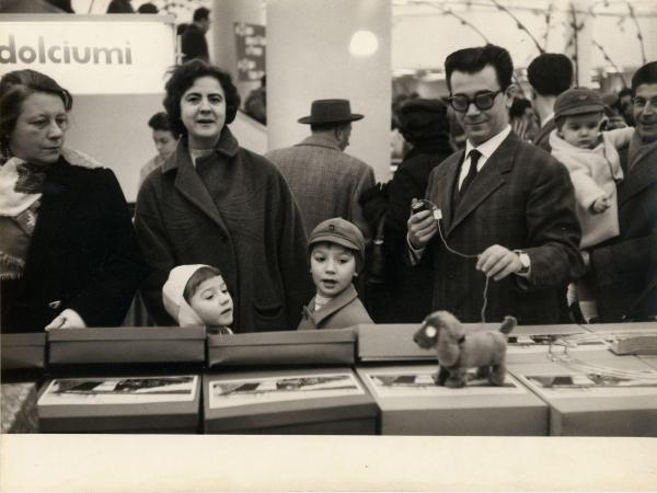 Milano - Rinascente - Grandi magazzini - Interno - Donne, uomini e bambini tra le corsie - Banco con cane con movimento - Merce - Giocattoli