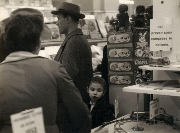 Milano - Upim - Grandi magazzini - Interno - Bambina e uomo tra le corsie - Merce - Giocattoli - Pista trenino