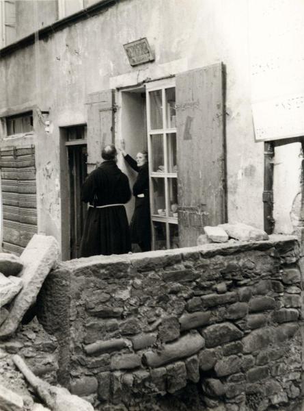 Villa Basilica (LU) - Esterno - Edificio - Negozio: merceria - Frate e donna sull'ingresso - Muro