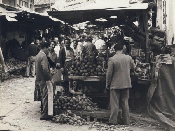 Grecia - Atene - Esterno - Mercato - Banchi di verdura con tende - Banco del fruttivendolo - Uomini - Carciofi