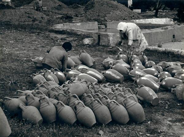 Grecia - Rodi - Fabbrica di anfore - Esterno - Donna e ragazzo, lavoratori - Verniciatura delle anfore