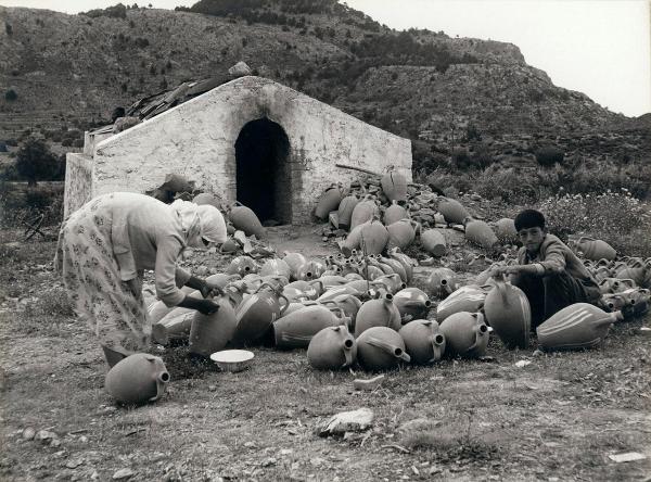 Grecia - Rodi - Fabbrica di anfore - Esterno - Donna e ragazzo, lavoratori - Verniciatura delle anfore