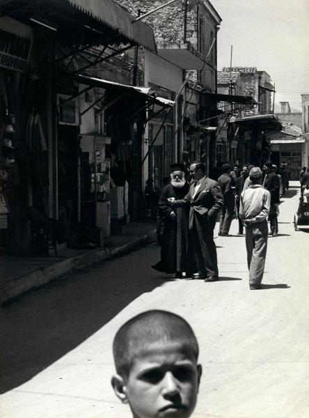 Grecia - Creta - Candia (Iraklio o Herakleio) - Via del Mercato, strada - Esterno - Testa di bambino in primo piano - Uomini, rabbino, passanti in secondo piano - Edifici