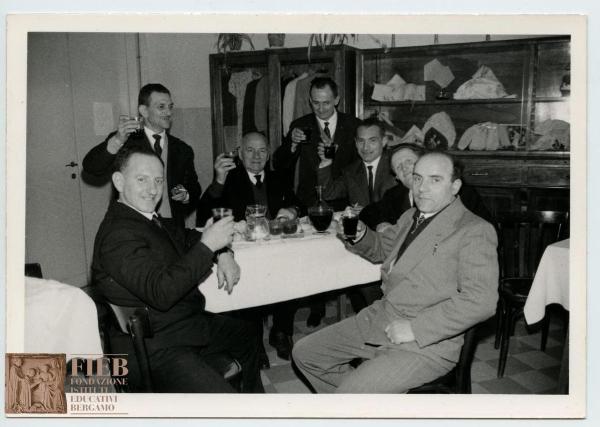 Orfanotrofio maschile di Bergamo - Interno - Sala da pranzo - Consiglio orfanotrofi - Foto di gruppo: consiglieri dell'orfanotrofio seduti a tavola brindano - Vino