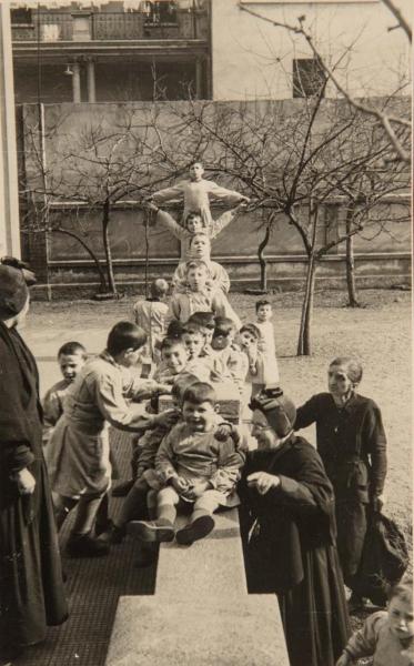 Milano - Pio Istituto dei Sordi - Esterno - Cortile - Bambini sordi, allievi della scuola materna, con Madre Teresa Bosisio, suora, e altra donna