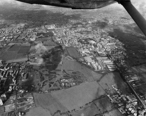 Milano / Bresso - Veduta aerea da sud a nord sull'area poi occupata dal Parco Nord, settore Niguarda, Bruzzano, Brusuglio, Aeroporto - Campi - Sfasciacorrozze - Cimitero di Bruzzano - Palazzi - Via Ornato - Aeroporto di Bresso - Pista di atterraggio