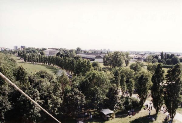 Sesto San Giovanni - Parco Nord, settore Est - Evento: Festa del Parco - Veduta dall'alto dalla mongolfiera da nord a sud - Prato - Filare dei pioppi cipressini - Percorsi ciclopedonali - Capannone Breda - Persone al parco - Boschi / Sullo sfondo palazzi di Milano