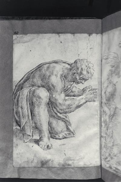Figura maschile inginocchiata con le mani giunte