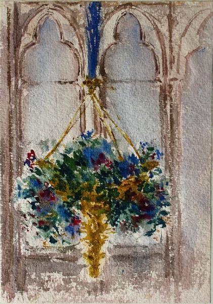 Vaso di fiori pensile davanti a una finestra ad archi polilobati