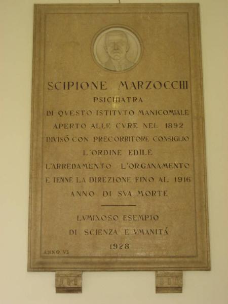 Lapide in memoria di Scipione Marzocchi, psichiatra, con tondo contenente ritratto marmoreo