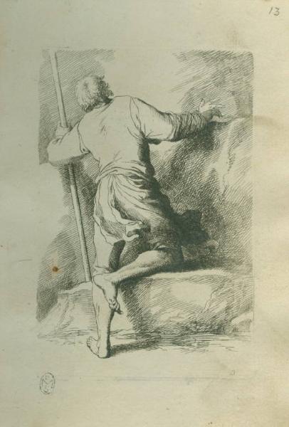 Uomo scalzo appoggiato ad un bastone con un ginocchio su una pietra