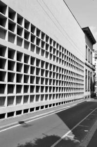 Dettaglio della facciata su via della Guastalla con le aperture quadrate e la superficie cieca della fascia superiore in corrispondenza della grande sala di lettura - fotografia di Suriano, Stefano (2016)
