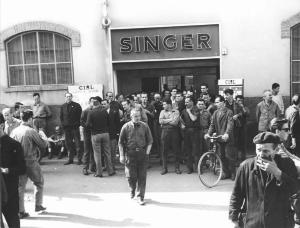 Sciopero dei lavoratori della Singer per il premio di produzione - Lavoratori davanti all'ingresso della fabbrica - Operai con tuta da lavoro - Cartelli Cisl - Insegna della Singer