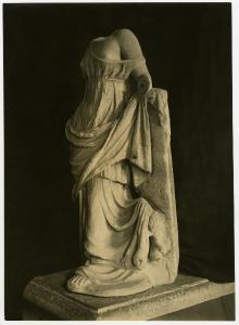 Aquileia - Museo Archeologico. Statua femminile acefala con veste panneggiata, ripresa di tre quarti, scultura in pietra.