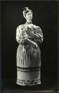 Bari - Raccolta Avv. Maselli. Fiasca in ceramica decorata a forma di donna con abito lungo e maniche a sbuffo della fabbrica di Grottaglie (inizi XIX sec.).